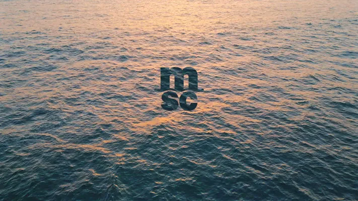 Meerwasser mit einer leichten Sonnenreflexion bei Sonnenuntergang und dem schwarzen MSC-Logo in der Mitte.
