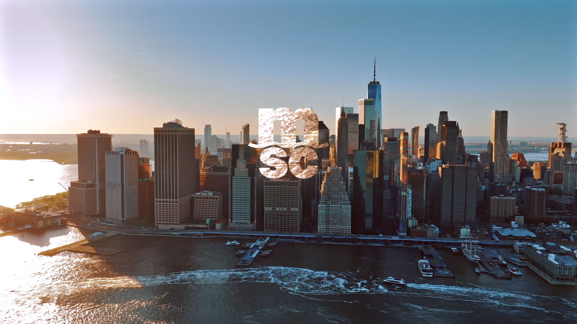 Luftaufnahme der Skyline von Manhattan mit der aufgehenden Sonne und dem MSC-Logo in der Bildmitte.