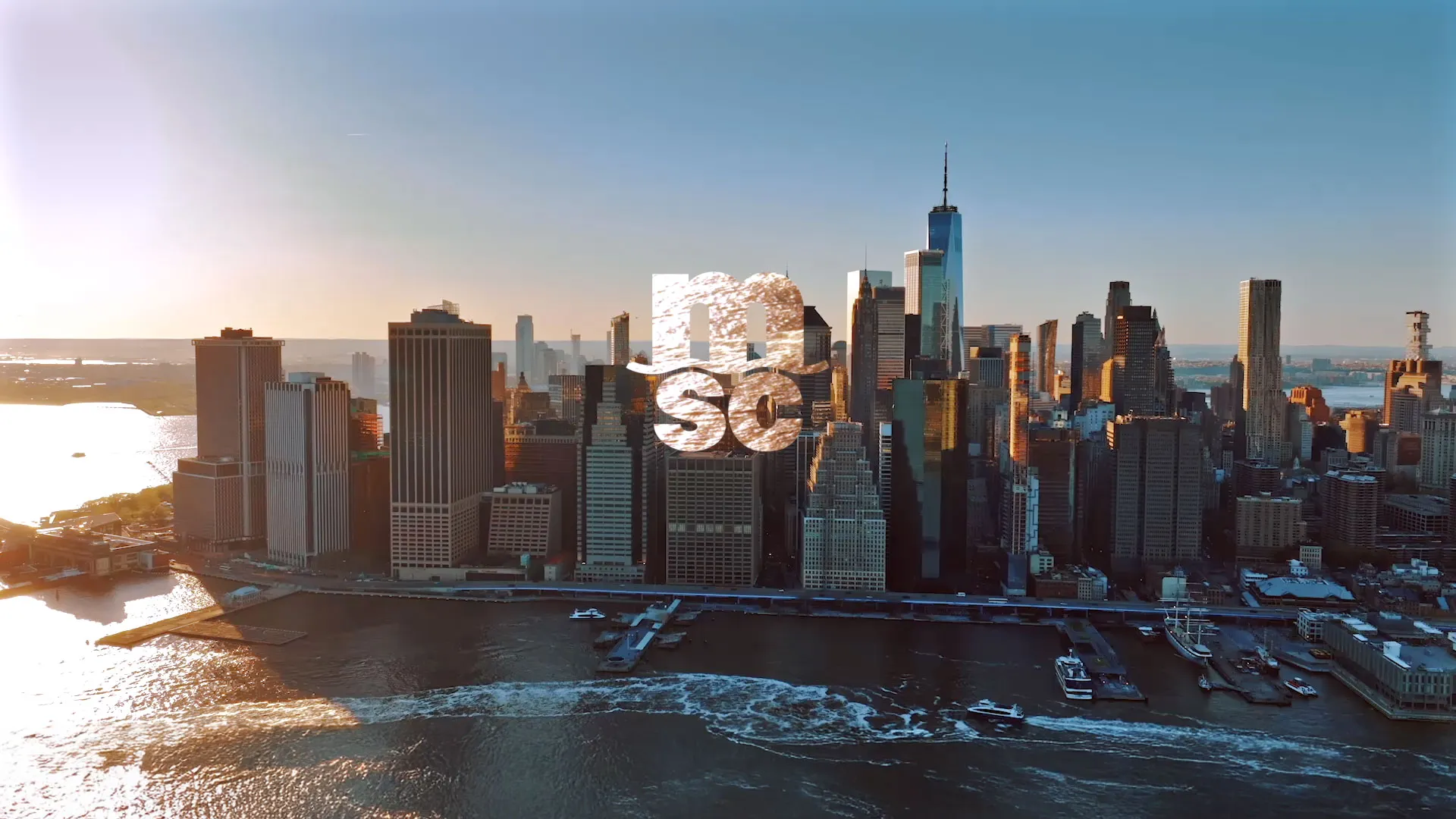 Luftaufnahme der Skyline von Manhattan mit der aufgehenden Sonne und dem MSC-Logo in der Bildmitte.
