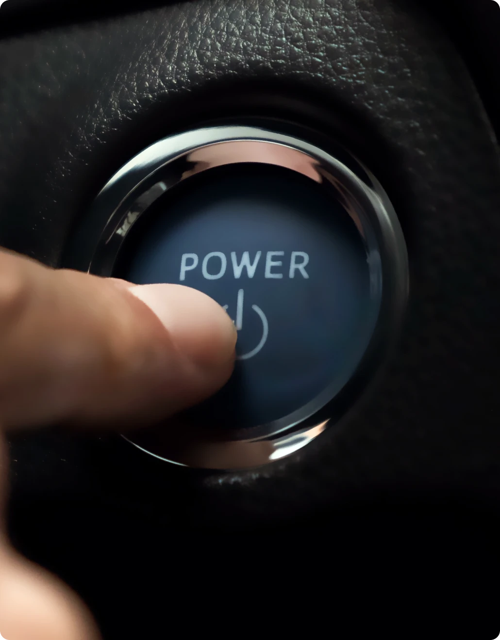 A hybrid vehicle's power button being pressed by the owner.