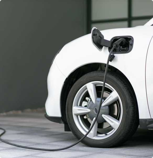 White electric car (EV) being charged at a charging station powered by sustainable and clean energy.
