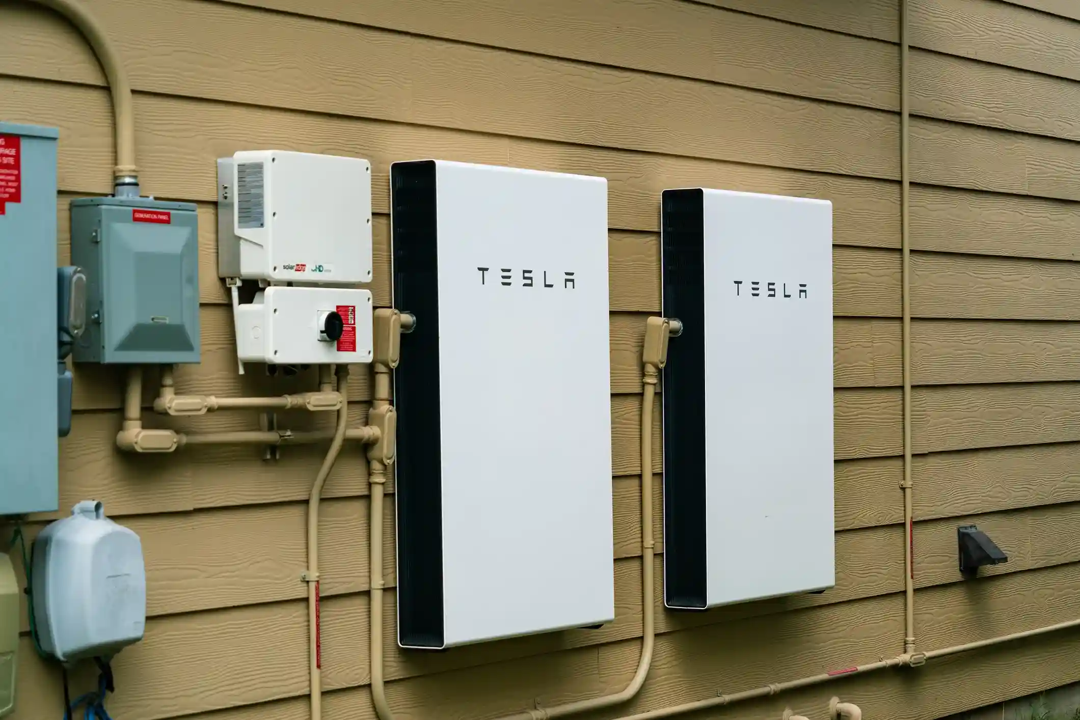 Sleek, modern Tesla Powerwall home energy storage system installed on an interior wall.