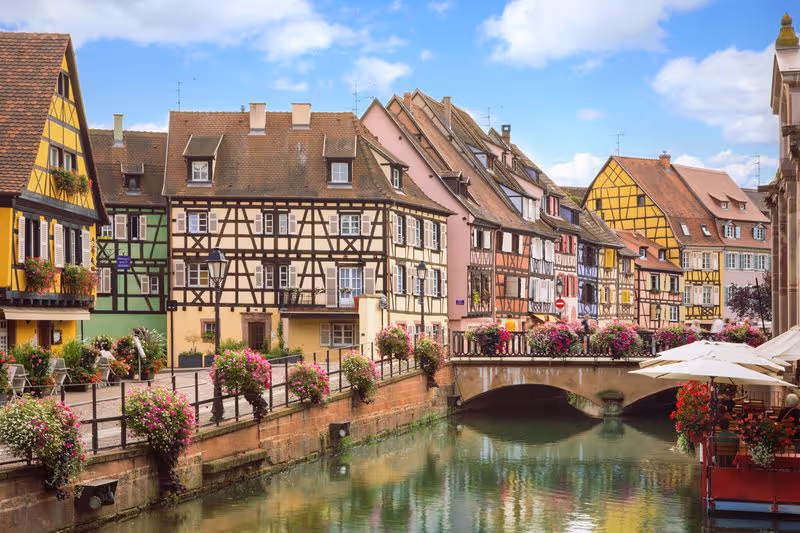 Maisons alsaciennes traditionnelles et canal fleuri dans le quartier de la Petite Venise à Colmar.