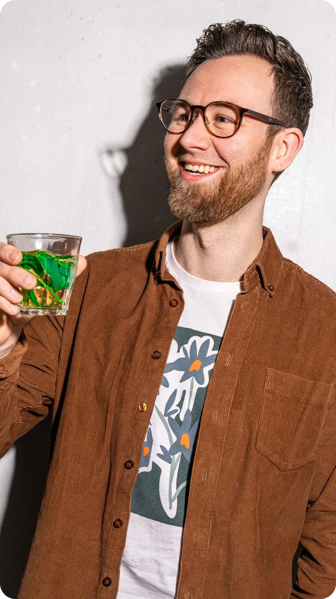 Lachende man proost met muntthee van werkfruit van Froot, onderdeel van Froot’s missie voor vitaliteit op kantoor.