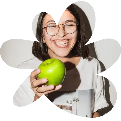 Lachende medewerker met appel als symbool voor gezonde werkcultuur en erkenning