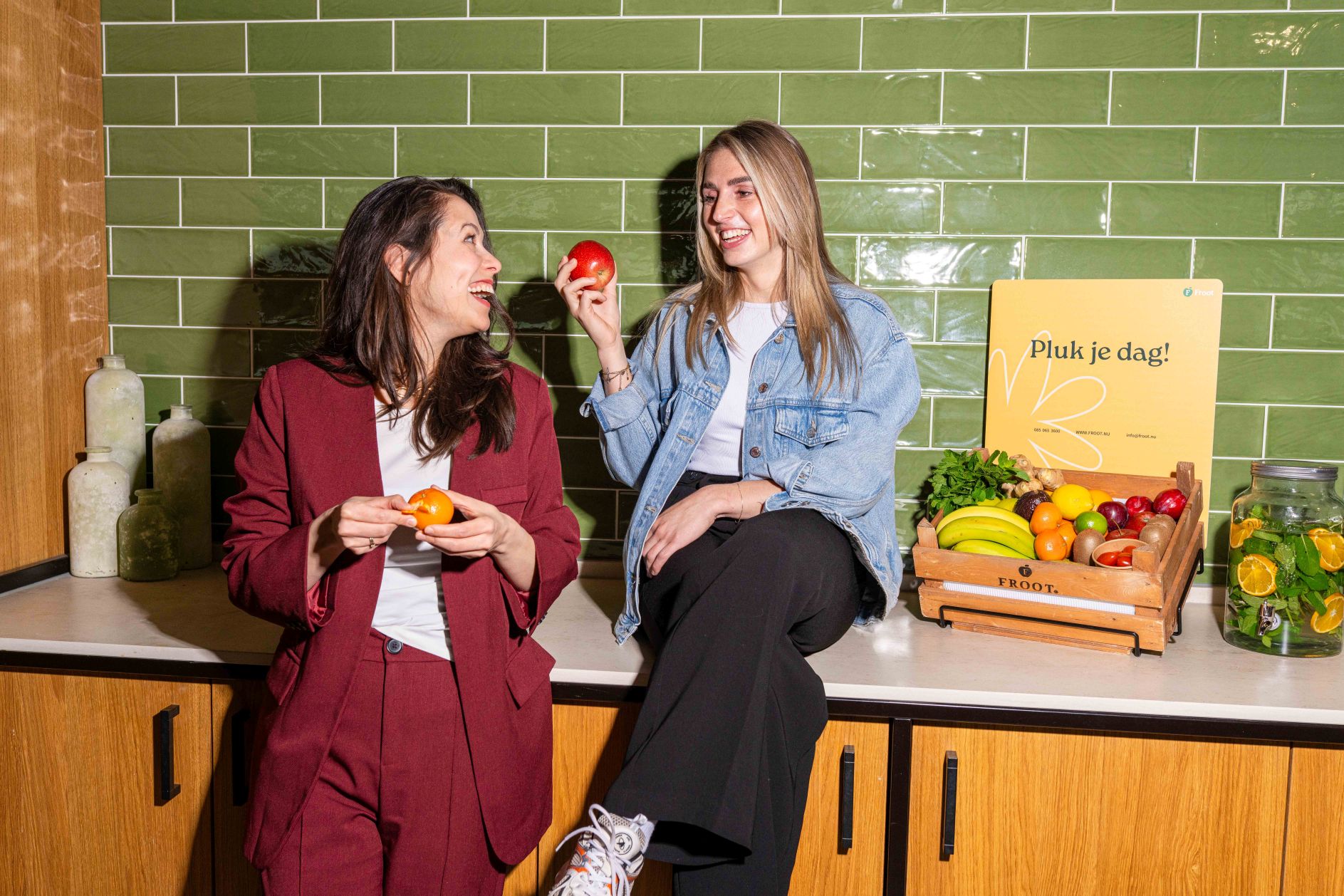 Betrokken medewerkers lachen naar elkaar met werkfruit van Froot
