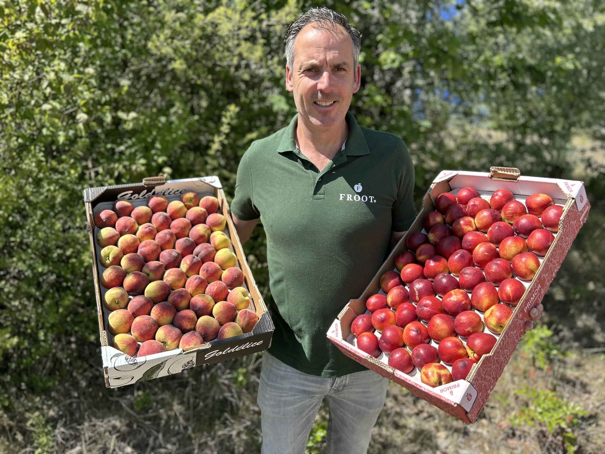 Froot inkoper Jeroen Beekman met duurzame seizoensperziken en nectarines van lokale telers, onderdeel van een CO₂-prestatieladder gecertificeerd inkoopproces.