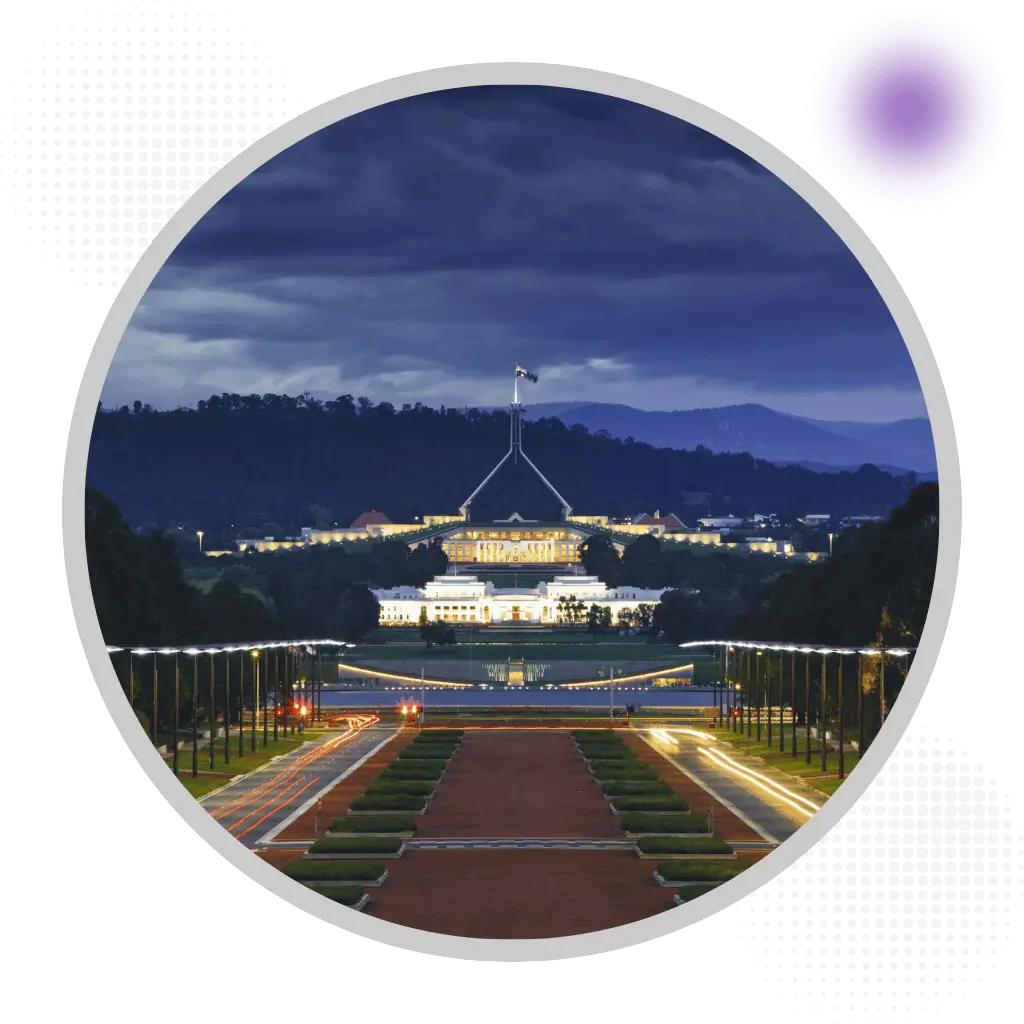 Australian Parliament House illuminated at night in Canberra with ceremonial avenue approach