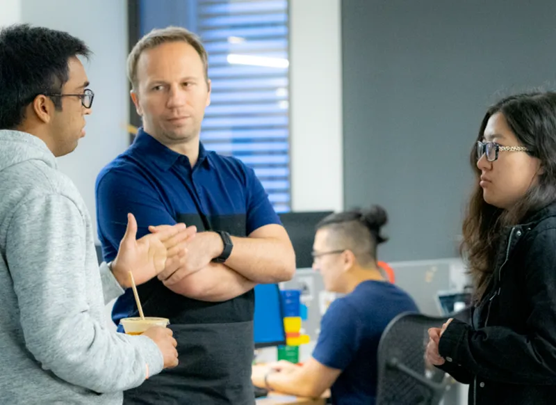 A man in a blue shirt is talking to a woman in a black jacket.