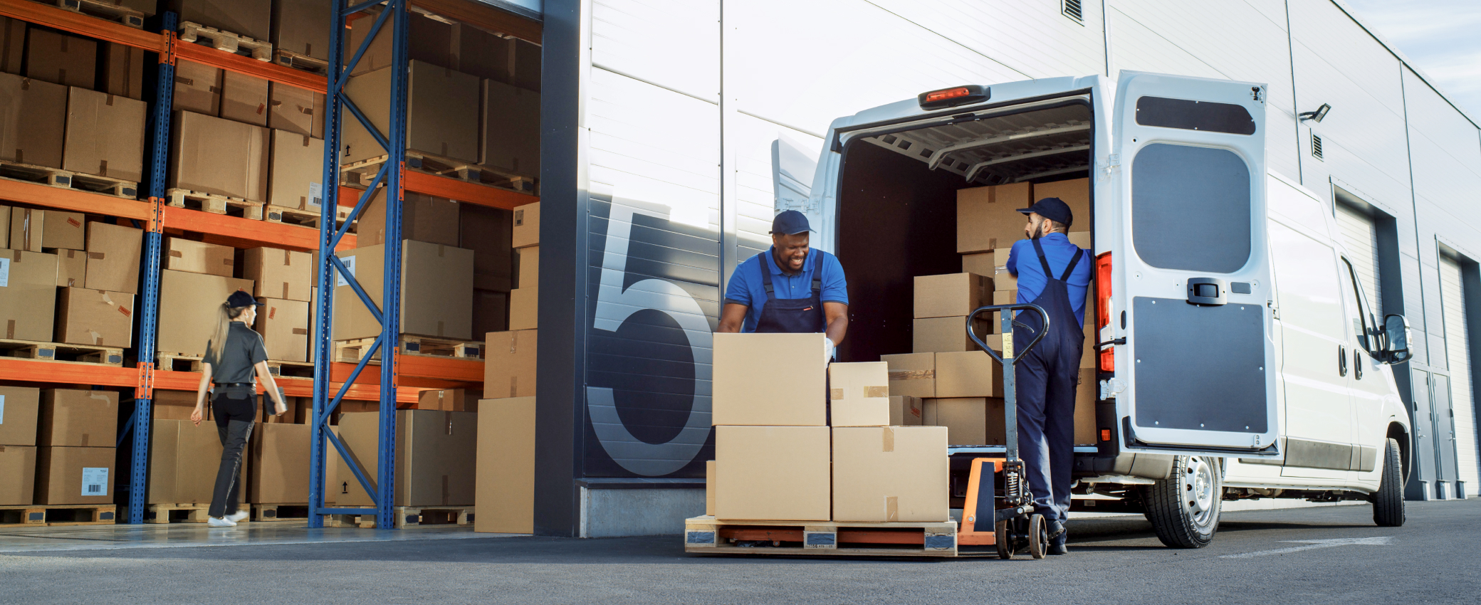 Warehouse workers unloading a van of packages for returns consolidation
