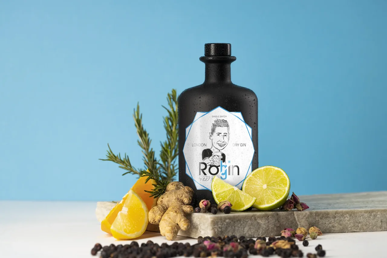 Produktfoto RobGin Gin-Flasche mit Limette, Ingwer und Rosmarin vor blauem Hintergrund – Studiofotografie von vibs.media