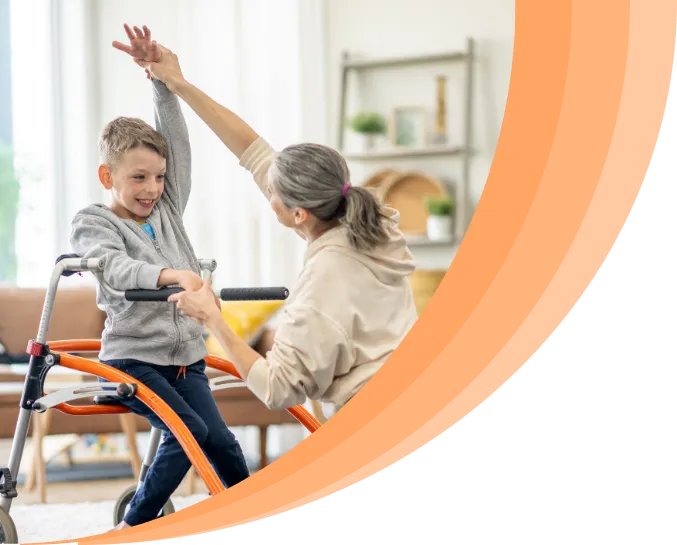 A therapist assisting a young boy using a walker with a stretching exercise in a supportive and encouraging environment.