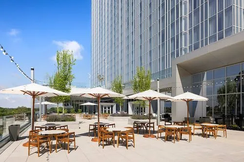 A group of tables and umbrellas outside of a building.
