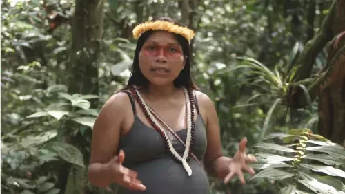 A woman wearing a headdress in a forest.