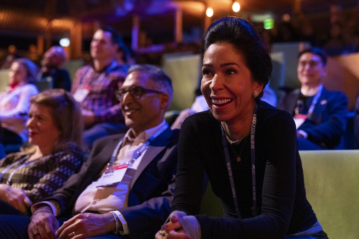 Audience member smiling and watching a TED Talk in the theater
