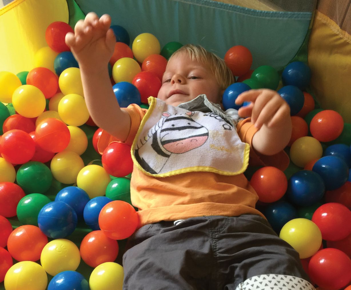 Kind liegt im bunten Bällebad