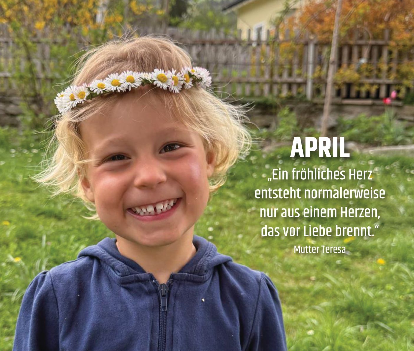 Fröhliches kleines Mädchen posiert auf einer grünen Wiese mit einem Blumenkranz im Haar.