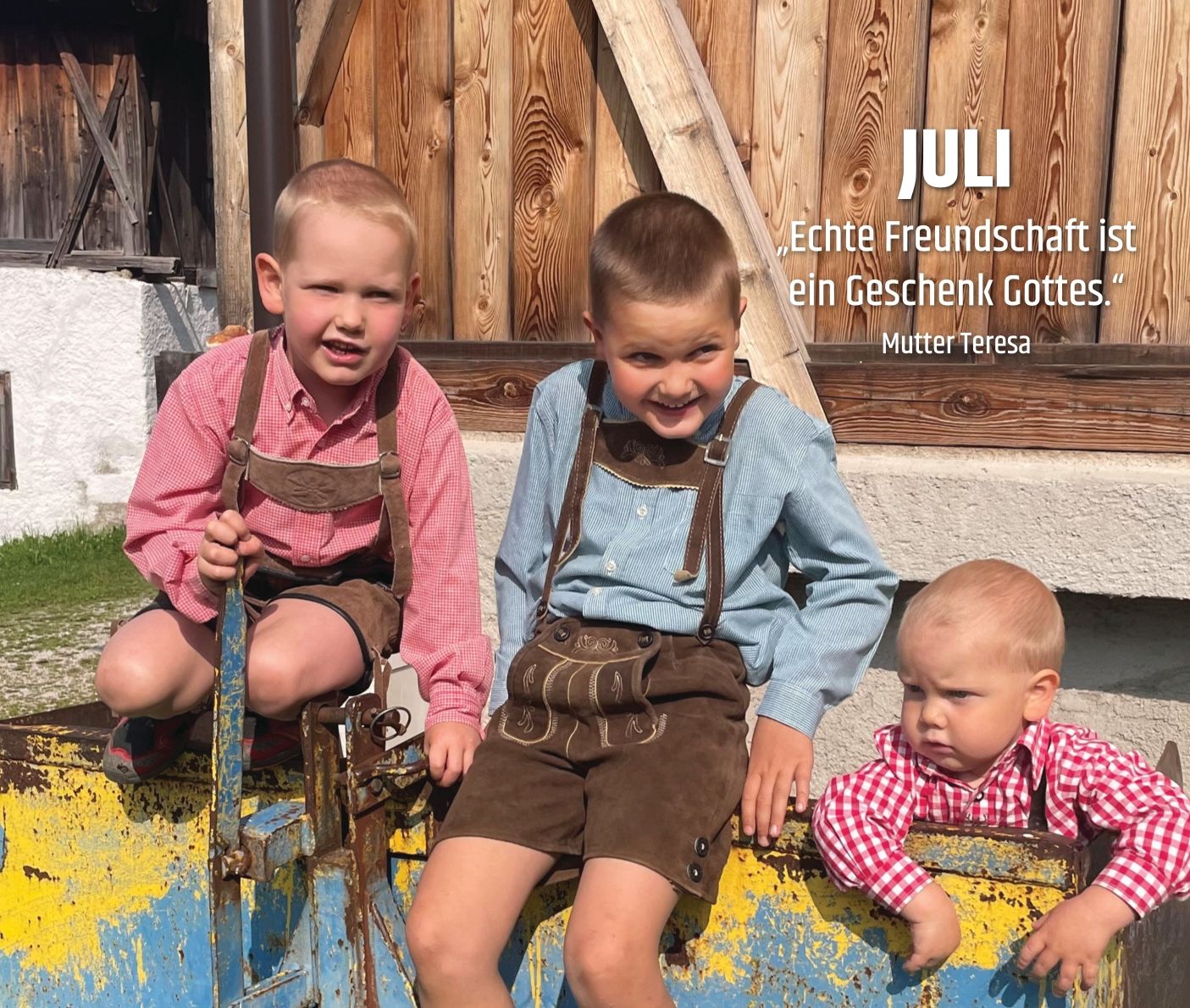 Drei Kinder spielen auf dem Traktor bei einem Bauernhof.