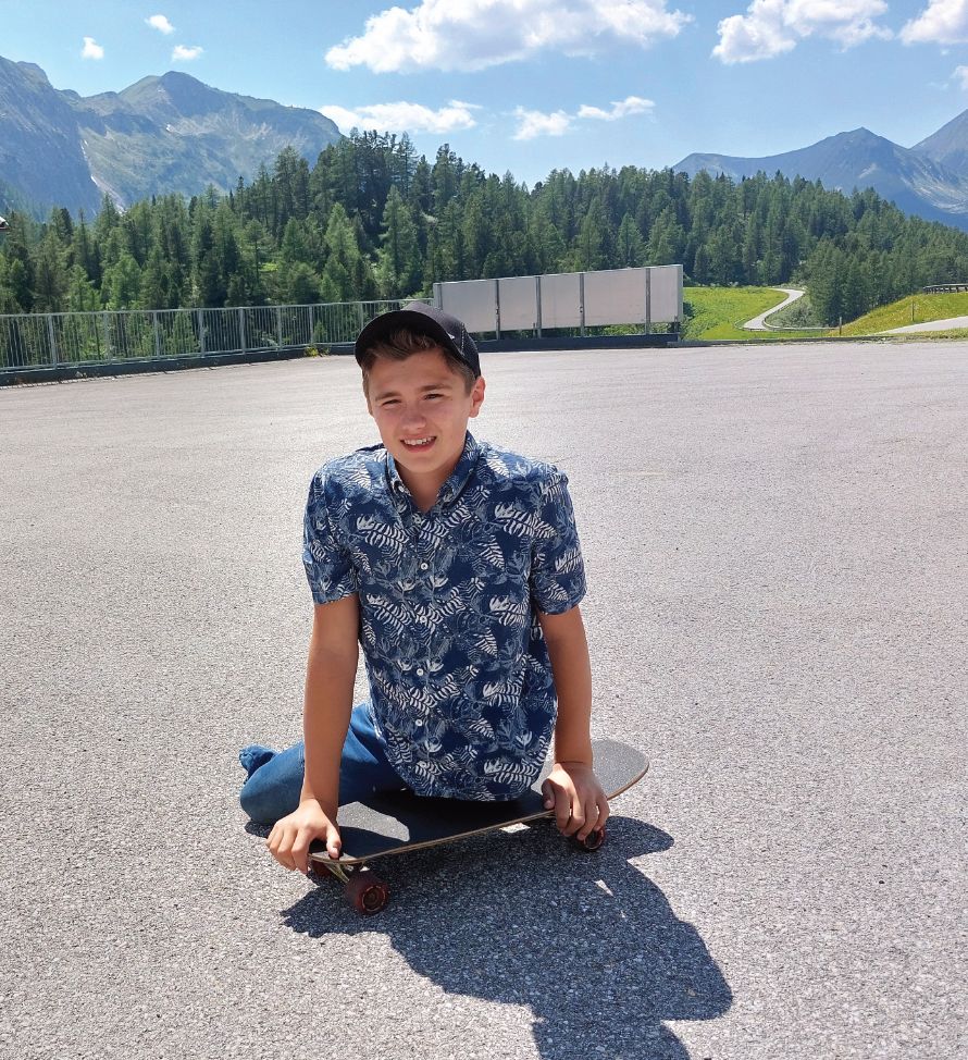 Junge ohne Beine fährt Skateboard