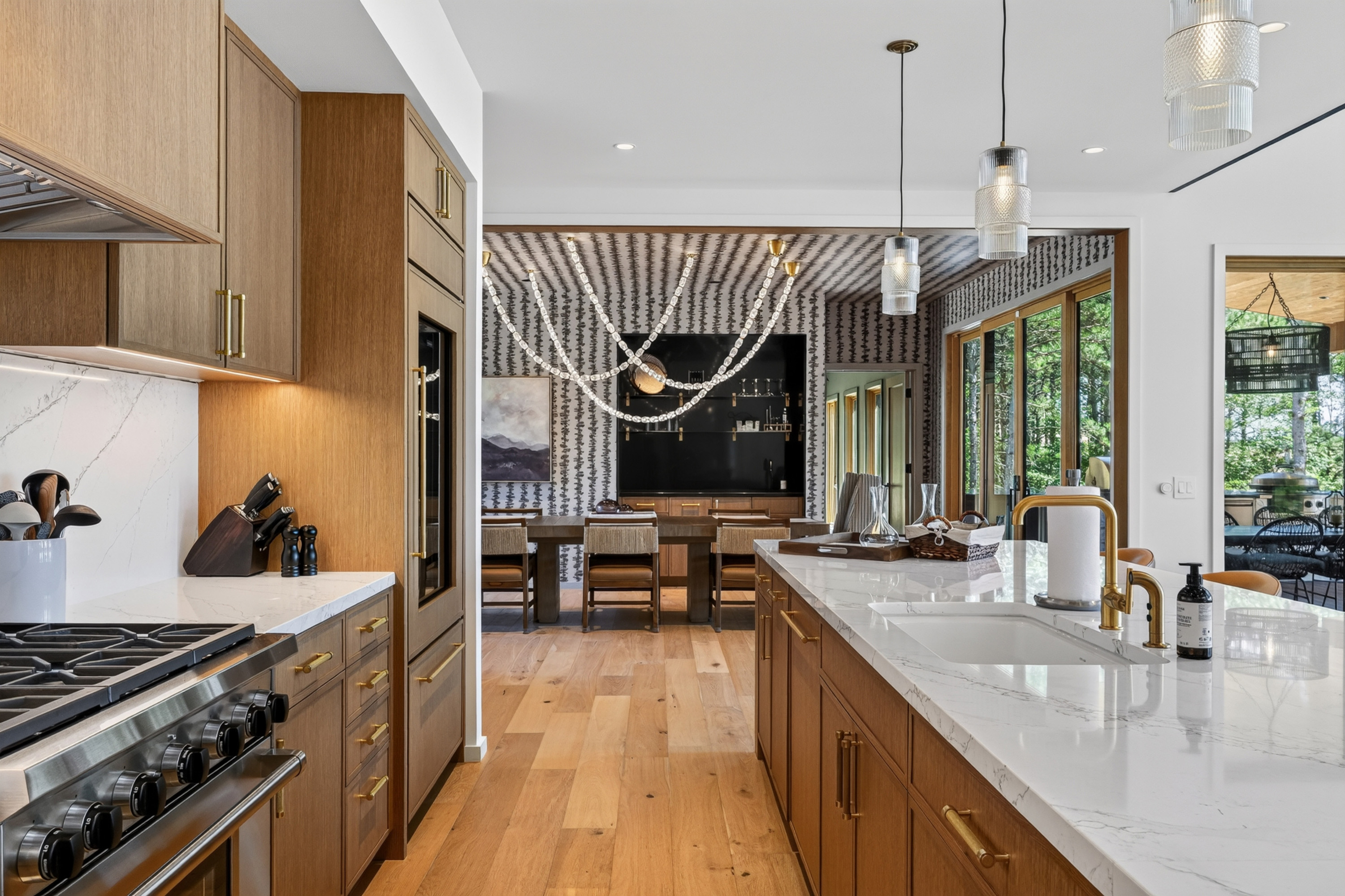Wood-paneled kitchen with marble countertops, island, and adjoining dining area.
