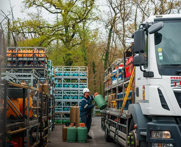 A photo of a man loading tank on the truck