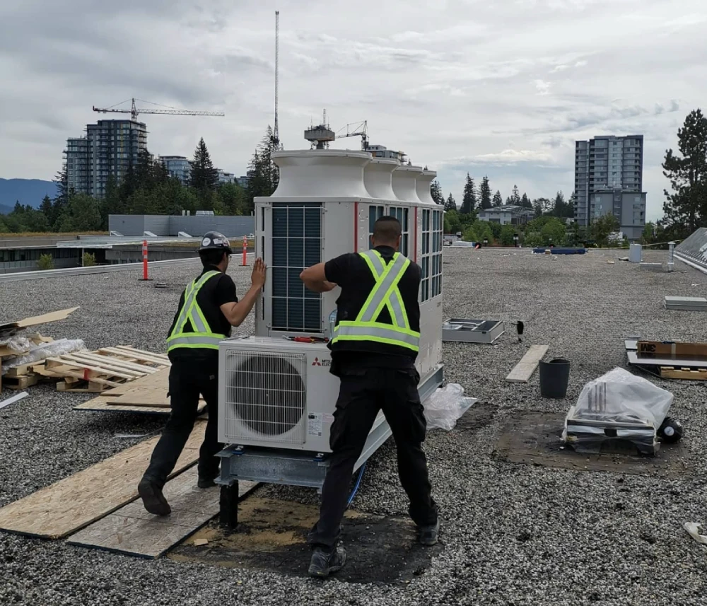 Commercial service technicians reviewing work together in a workshop.