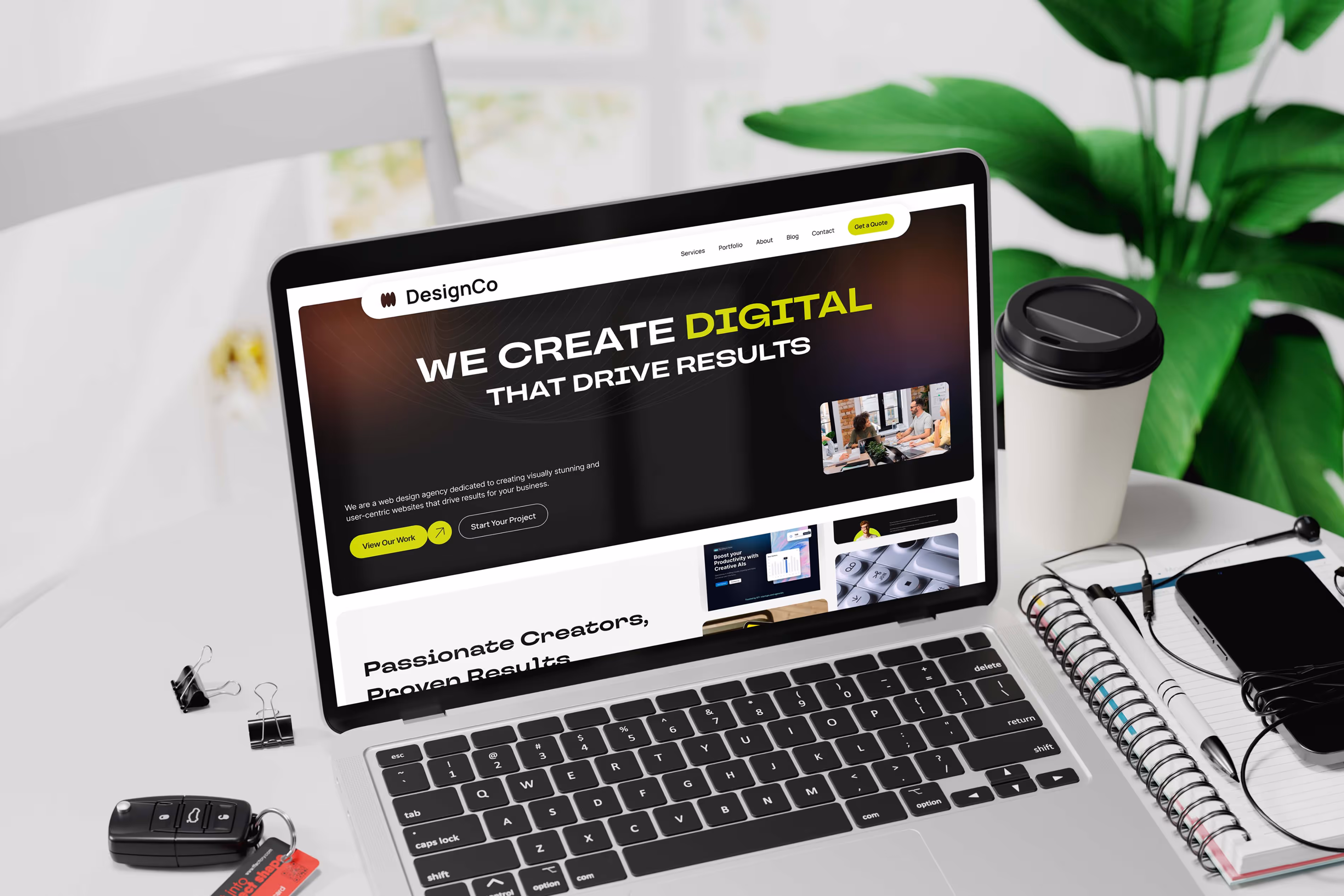 Laptop screen showing the DesignCo homepage with dark gradient hero section and conversion-focused messaging, placed on a modern workspace desk with books and decor.