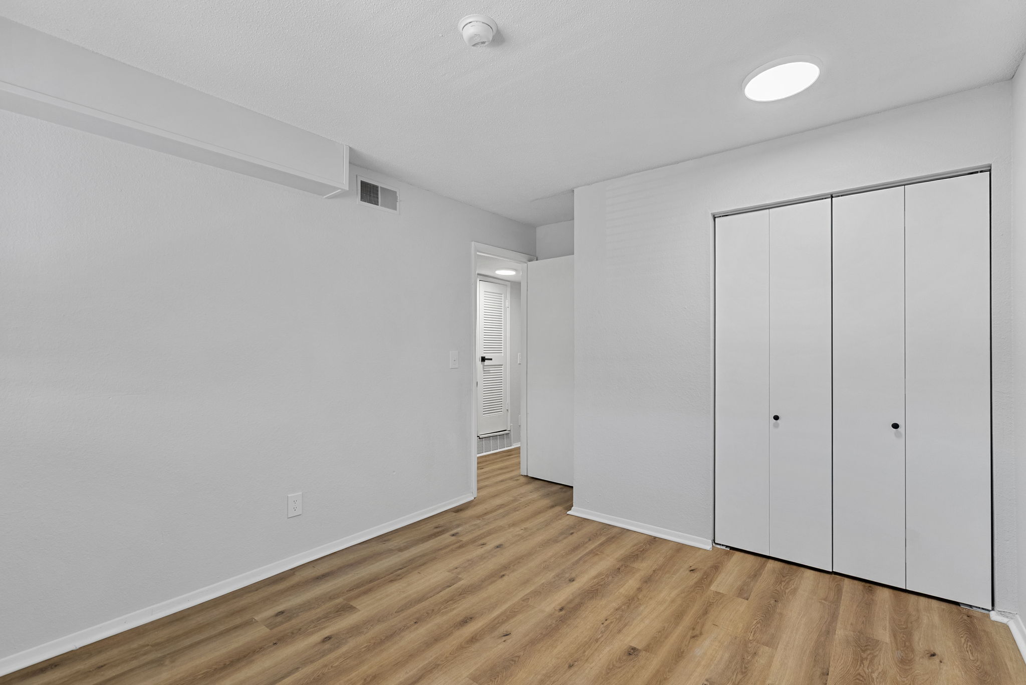 Unfurnished bedroom with wood floors