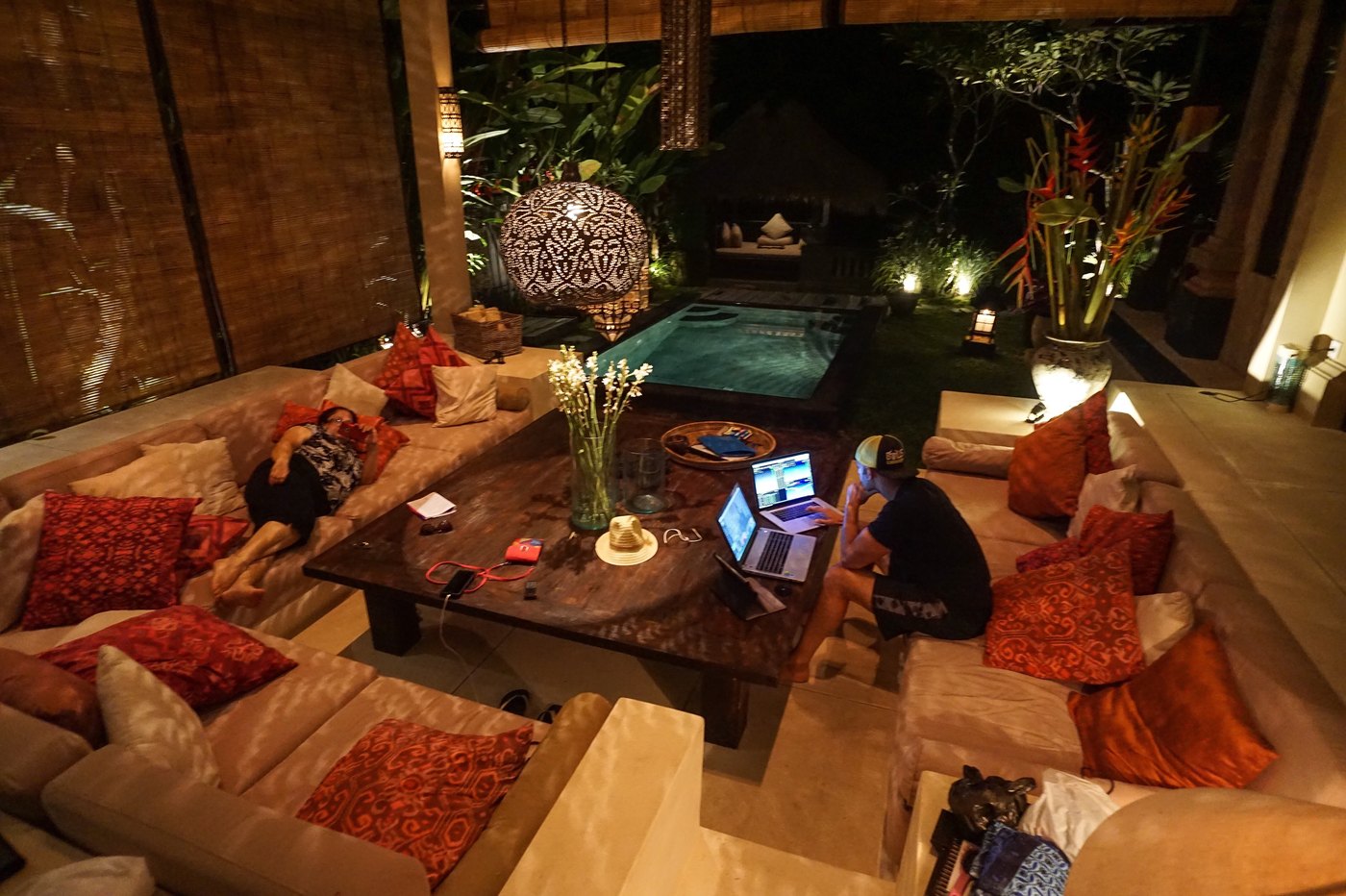 Kunal Desai trading from two laptops in a Bali villa at night in 2015 while his mother rests on the couch nearby