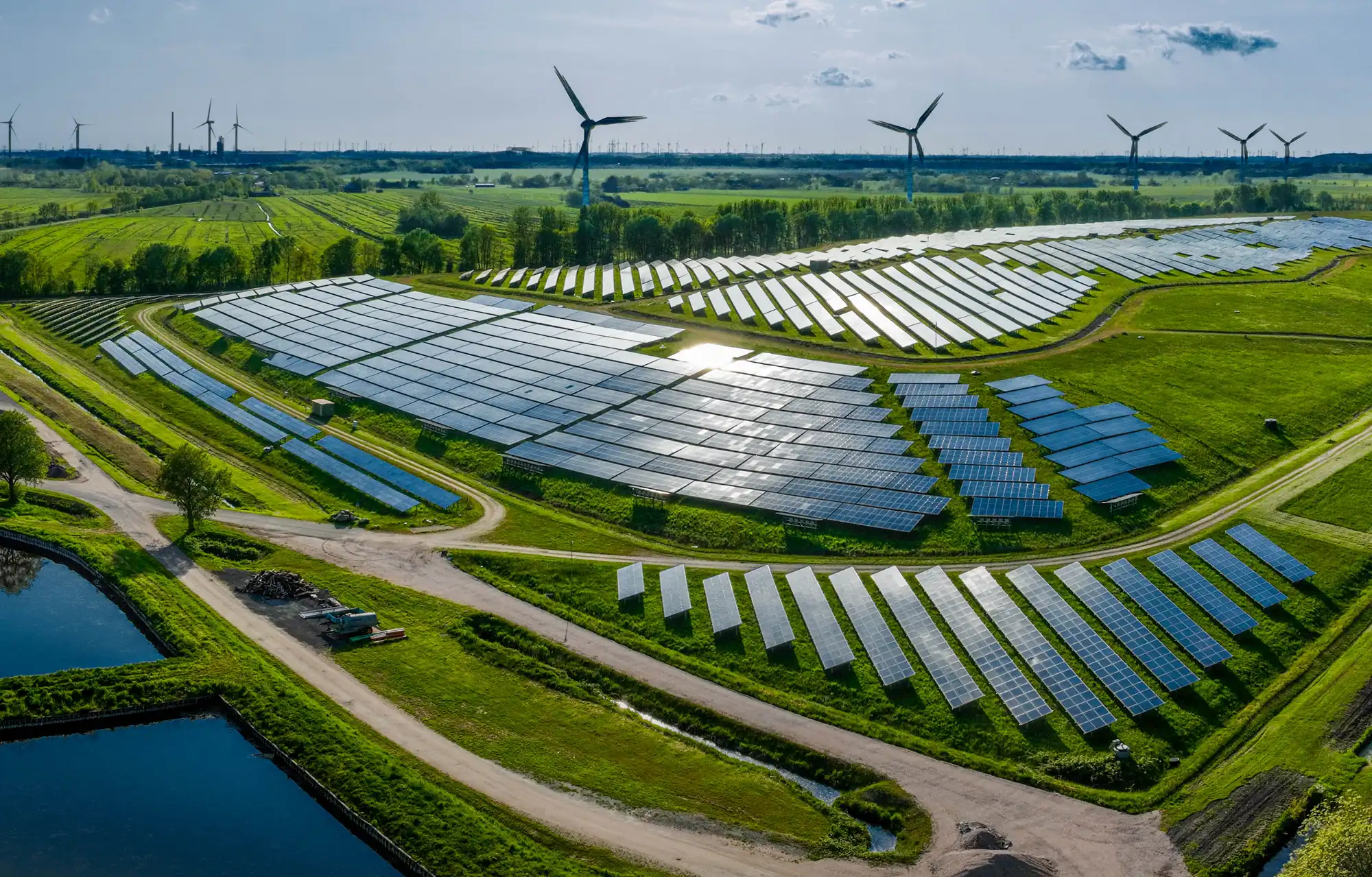 a modern clean energy facility in the south, showing a large array of solar panels, and windmills