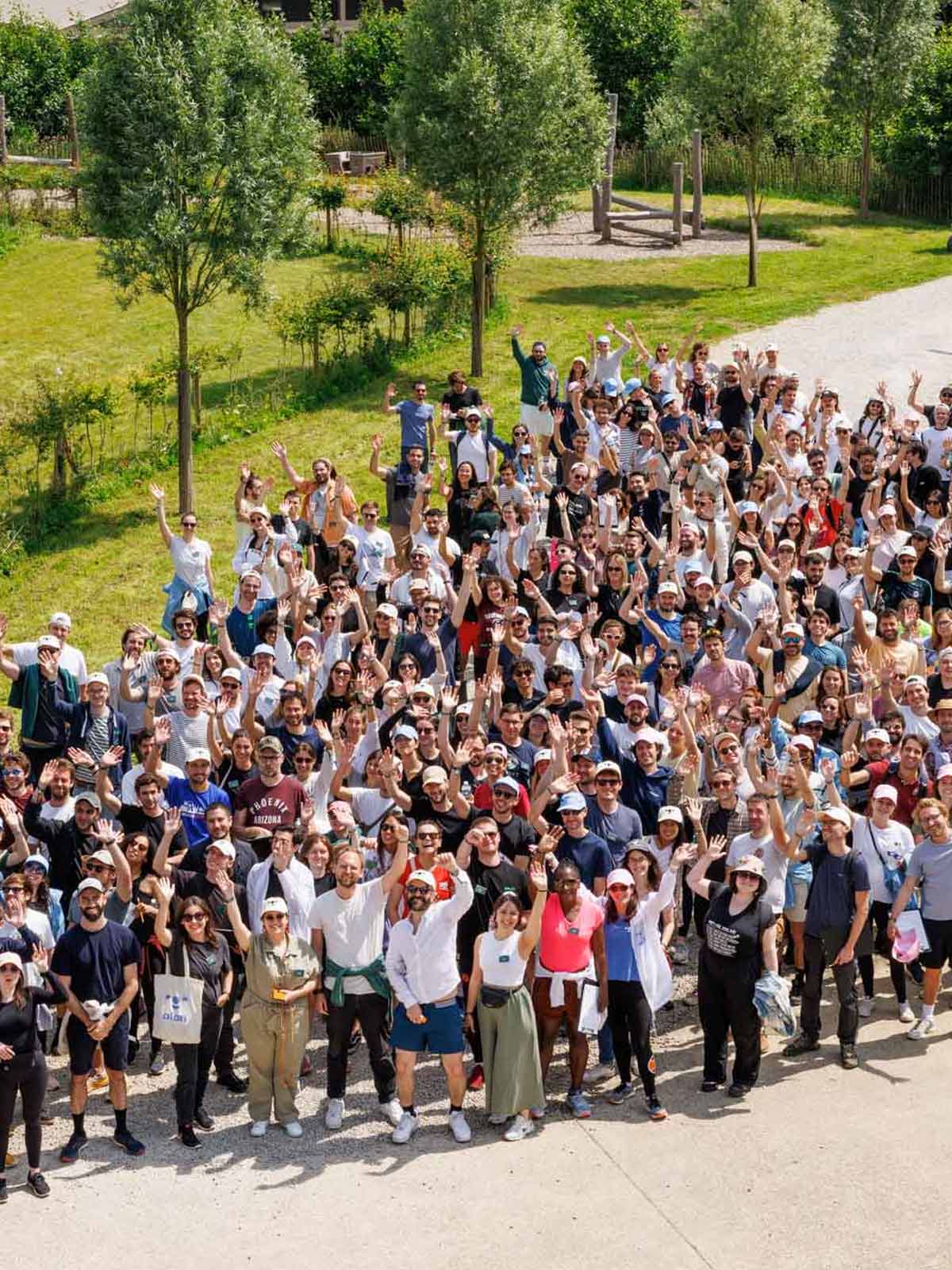 Une foule se rassemble en plein air sur une colline herbeuse pour un événement.