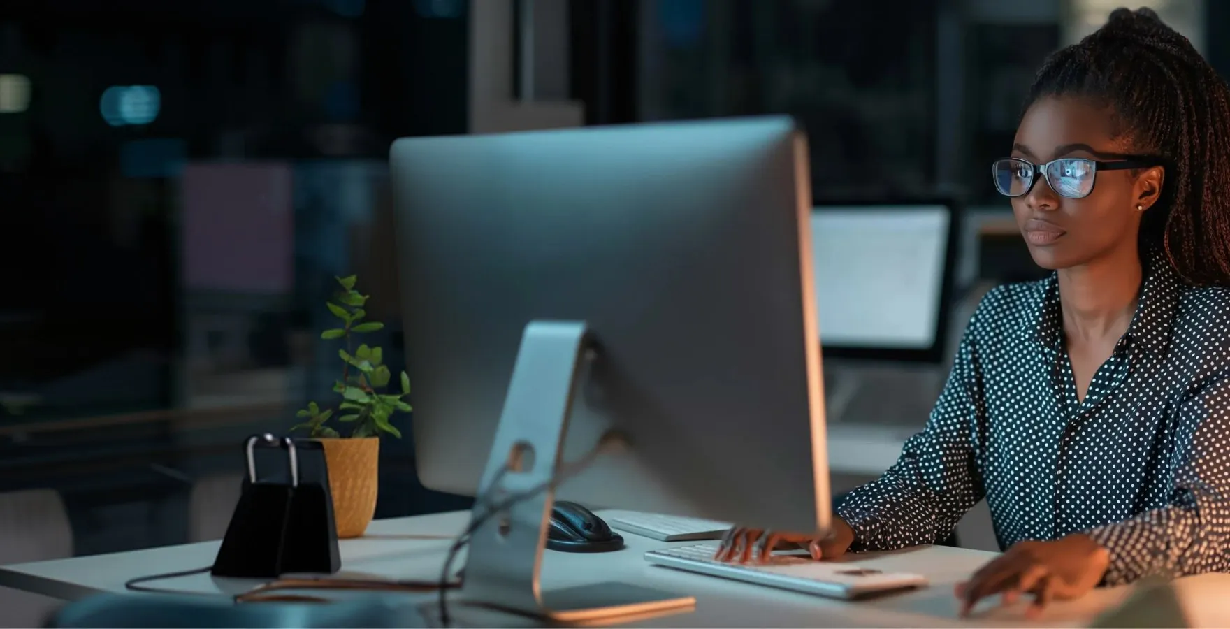 Audience seated and watching a speaker on stage in a dimly lit conference hall.