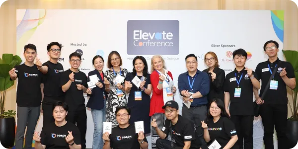 Conference stage with three large screens, one displaying text from IBTM World, the center showing Mickey Mouse in a wizard costume surrounded by labels like stage direction, music, props, lyrics, costume, theatrical timing, and breaking the fourth wall, and a person speaking on stage.