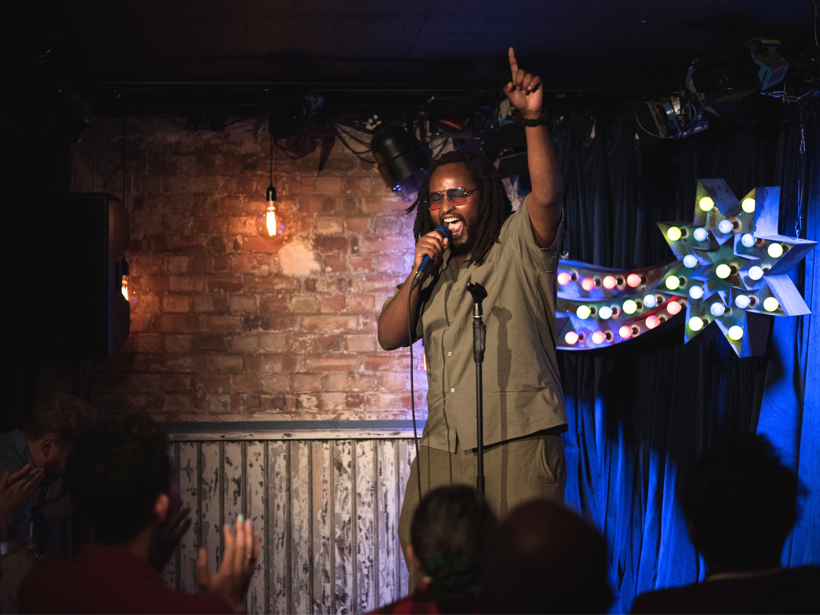 Comedian Fabrice Rango Looking Happy Performing in Venue With Brick Walls in Camden Comedy Freaks - Comedy Club London.