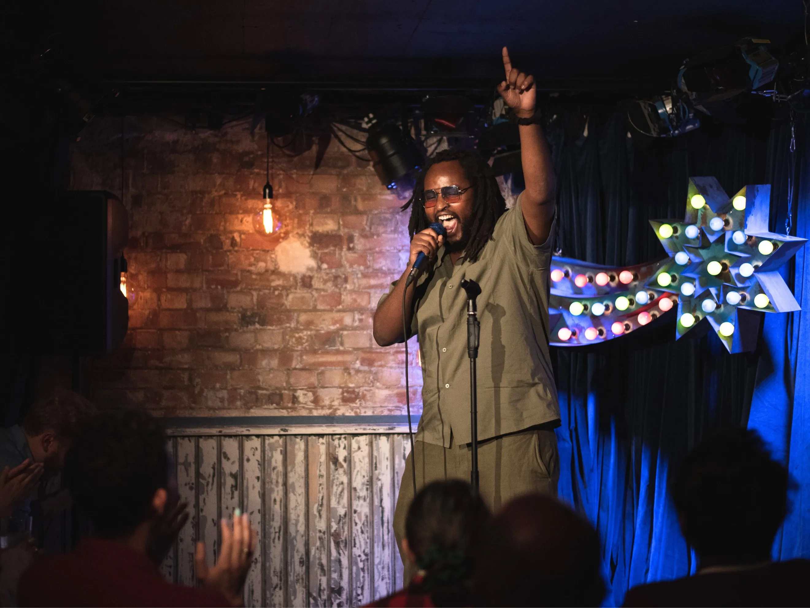 Comedian Fabrice Rango Looking Happy Performing in Venue With Brick Walls in Camden Comedy Freaks - Comedy Club London.