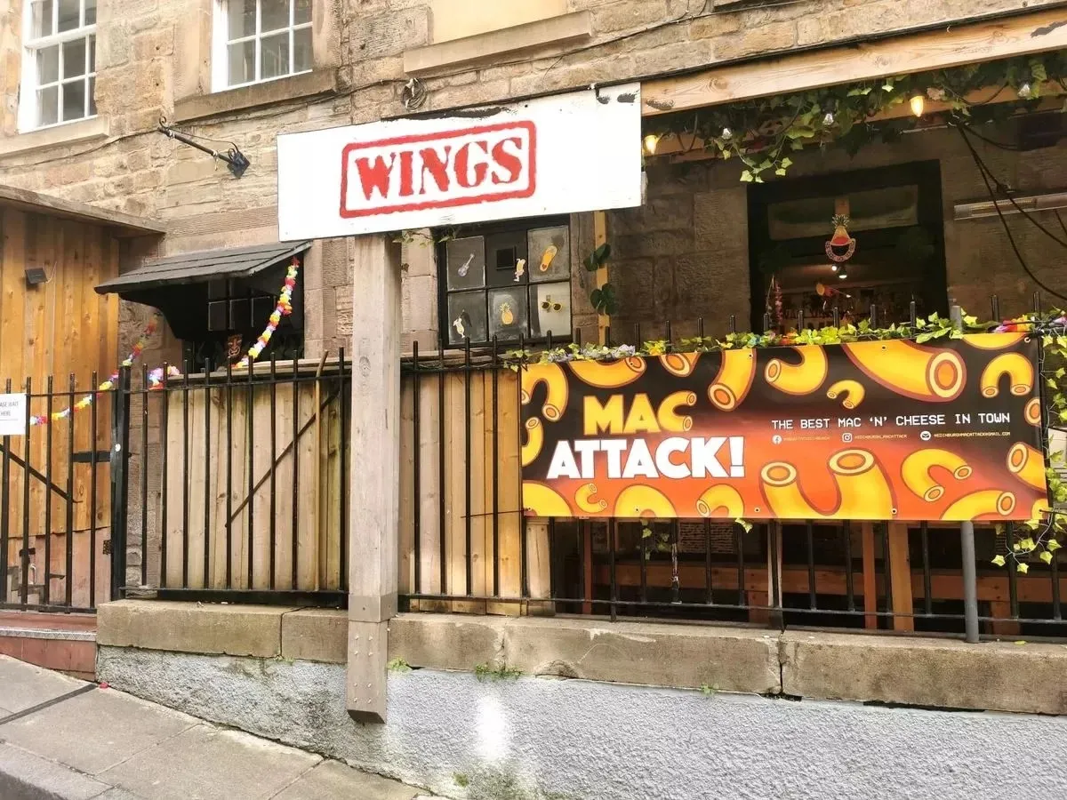 Wings restaurant exterior in Edinburgh showing Mac Attack banner - popular chicken wing spot near comedy venues.