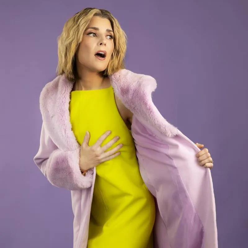 Grace Helbig comedian in pink coat promoting Edinburgh Fringe comedy show.