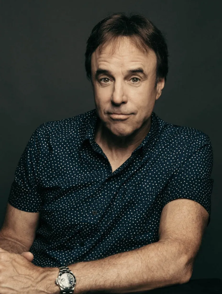 American comedian Kevin Nealon in a blue, patterned shirt, a familiar face in the London stand-up comedy scene.