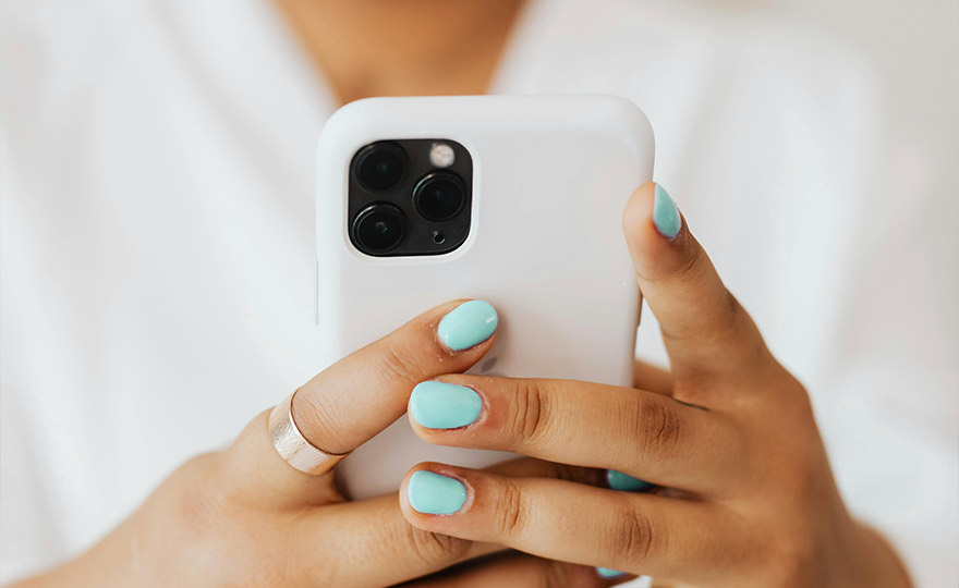 Frau hält Smartphone in den Händen - heller Hintergrund