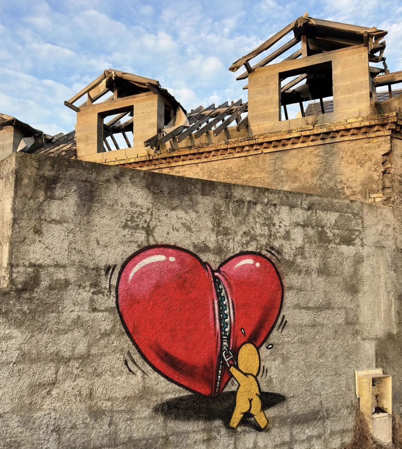 Fresque murale où le personnage Gouzou porte un gros coeur rouge sur son dos.