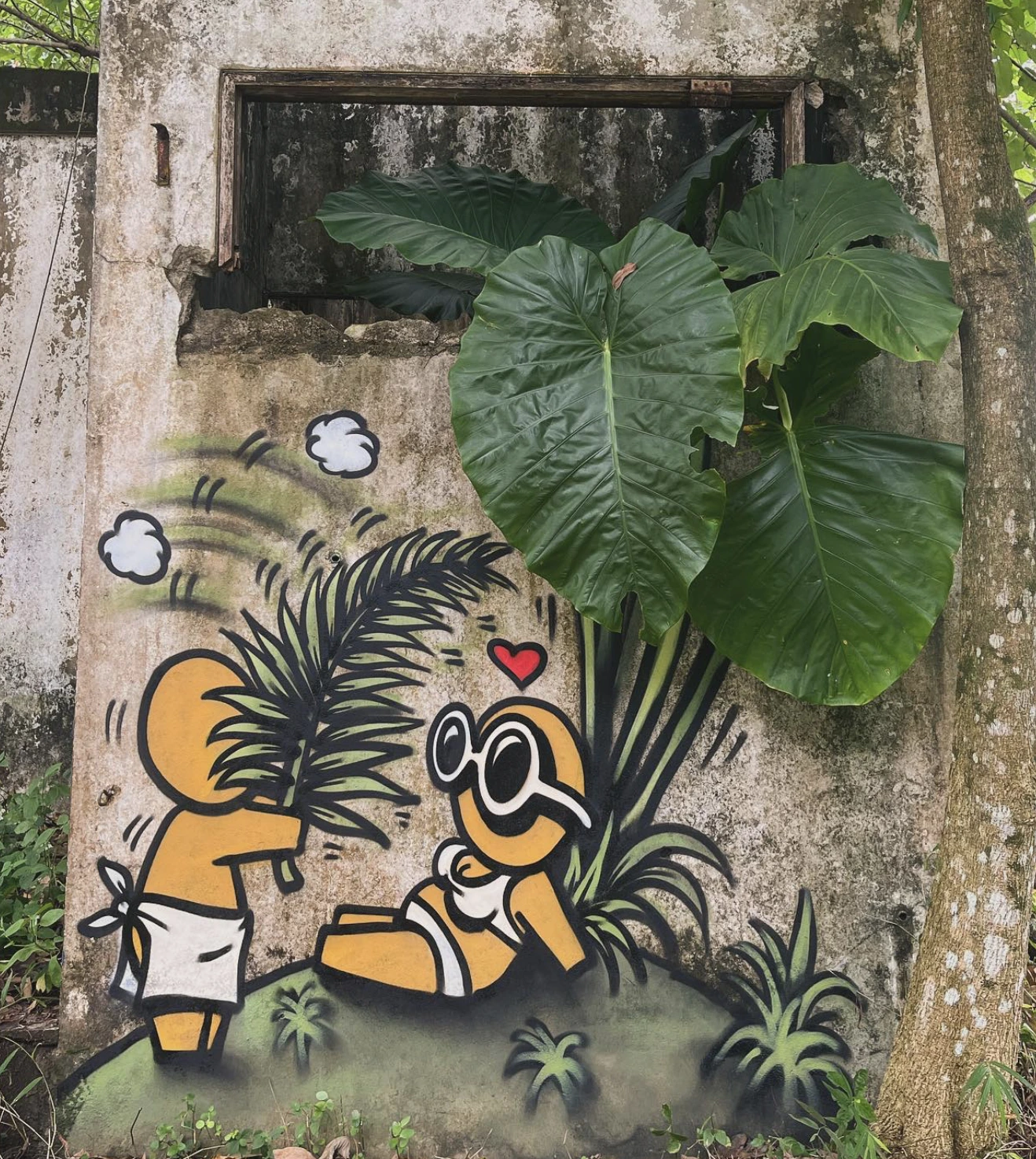 Fresque représentant un Gouzou faisant de l'air à un autre assis à l'ombre sur véritable plante.