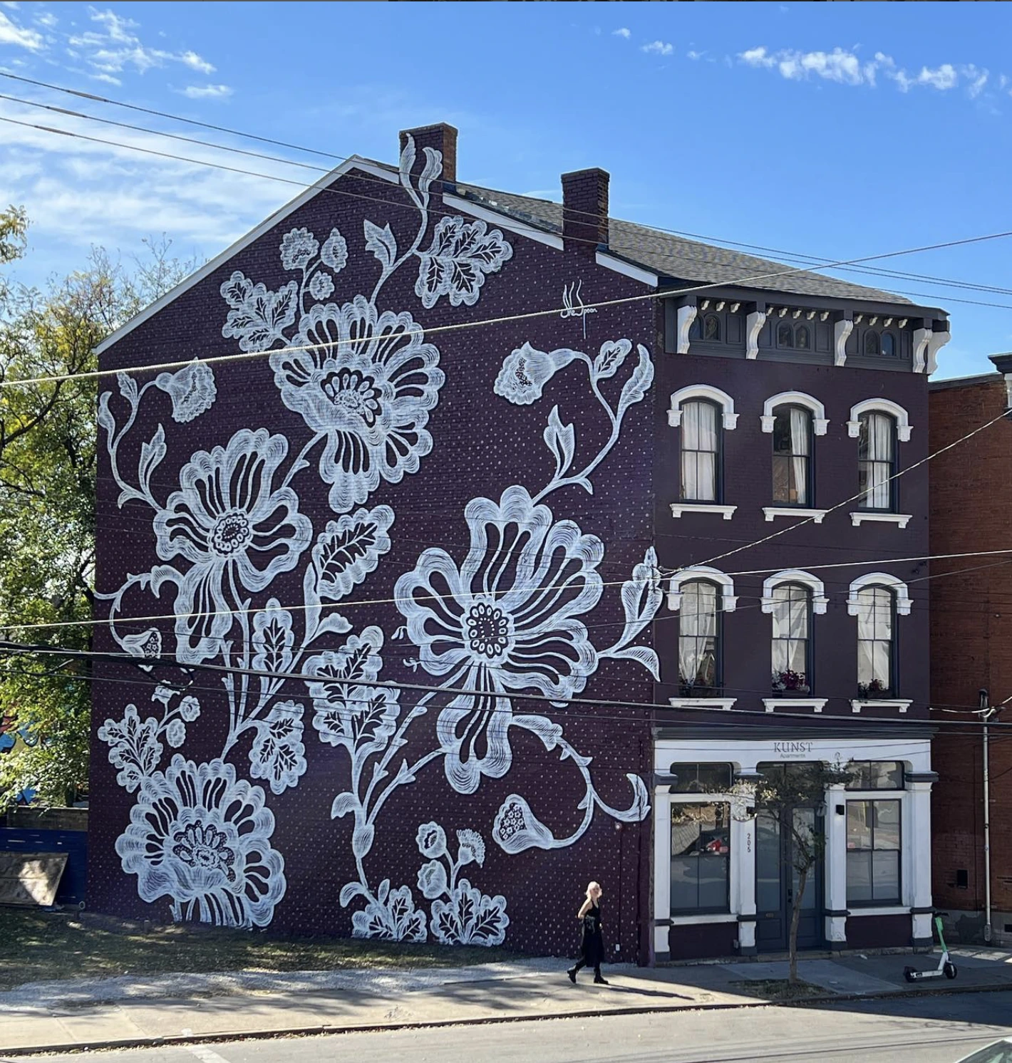 Fresque sur fond violet foncé avec différentes fleurs blanches et des feuilles blanches.