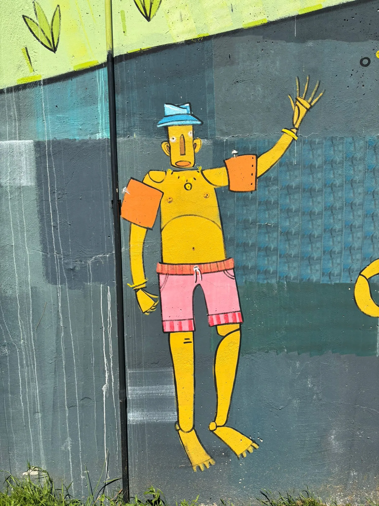 Détail de la fresque : on voit un bonhomme peint en jaune sur fond bleu.
