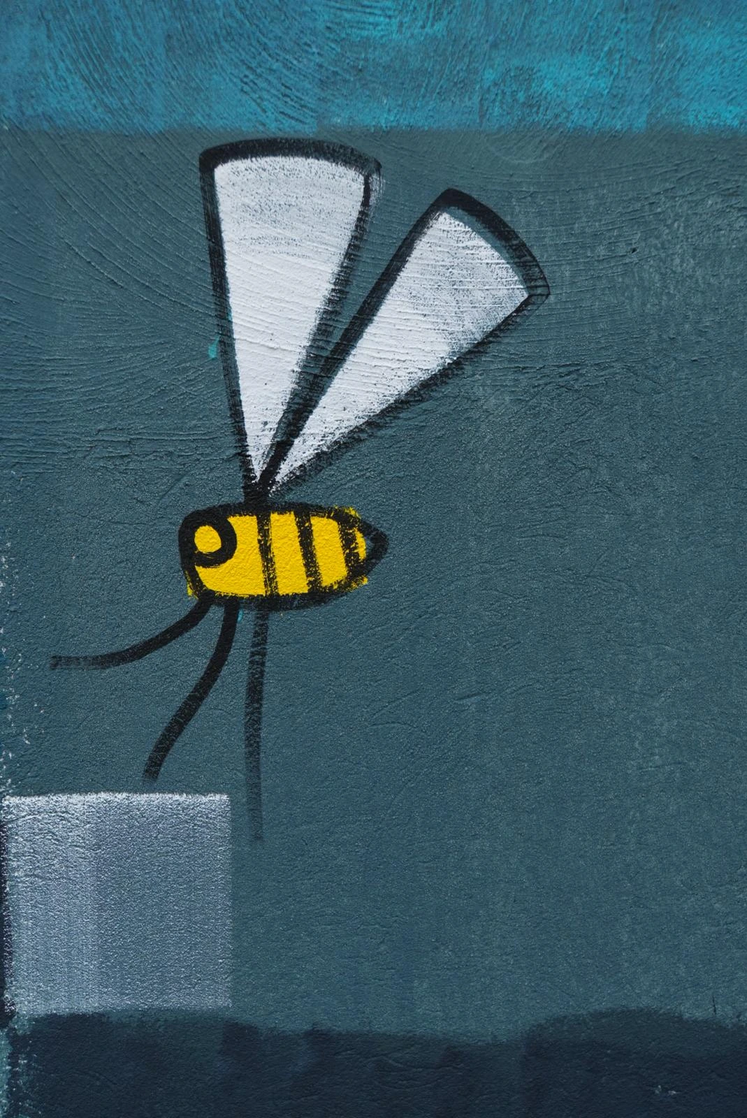 Détail de la fresque : une abeille en gros plan sur fond bleu.