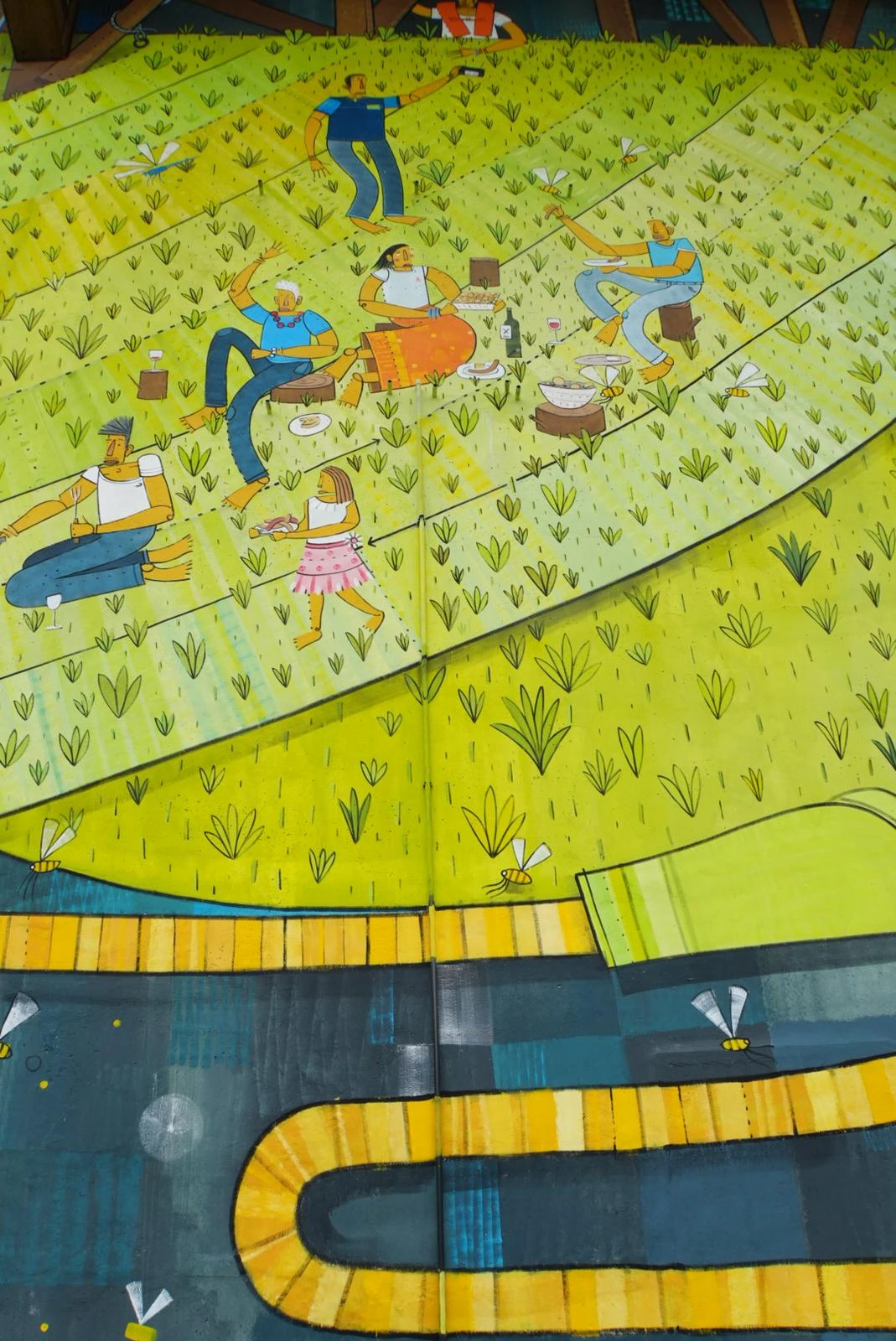 Détail de la fresque : scène de pique-nique avec une famille installée sur l'herbe.