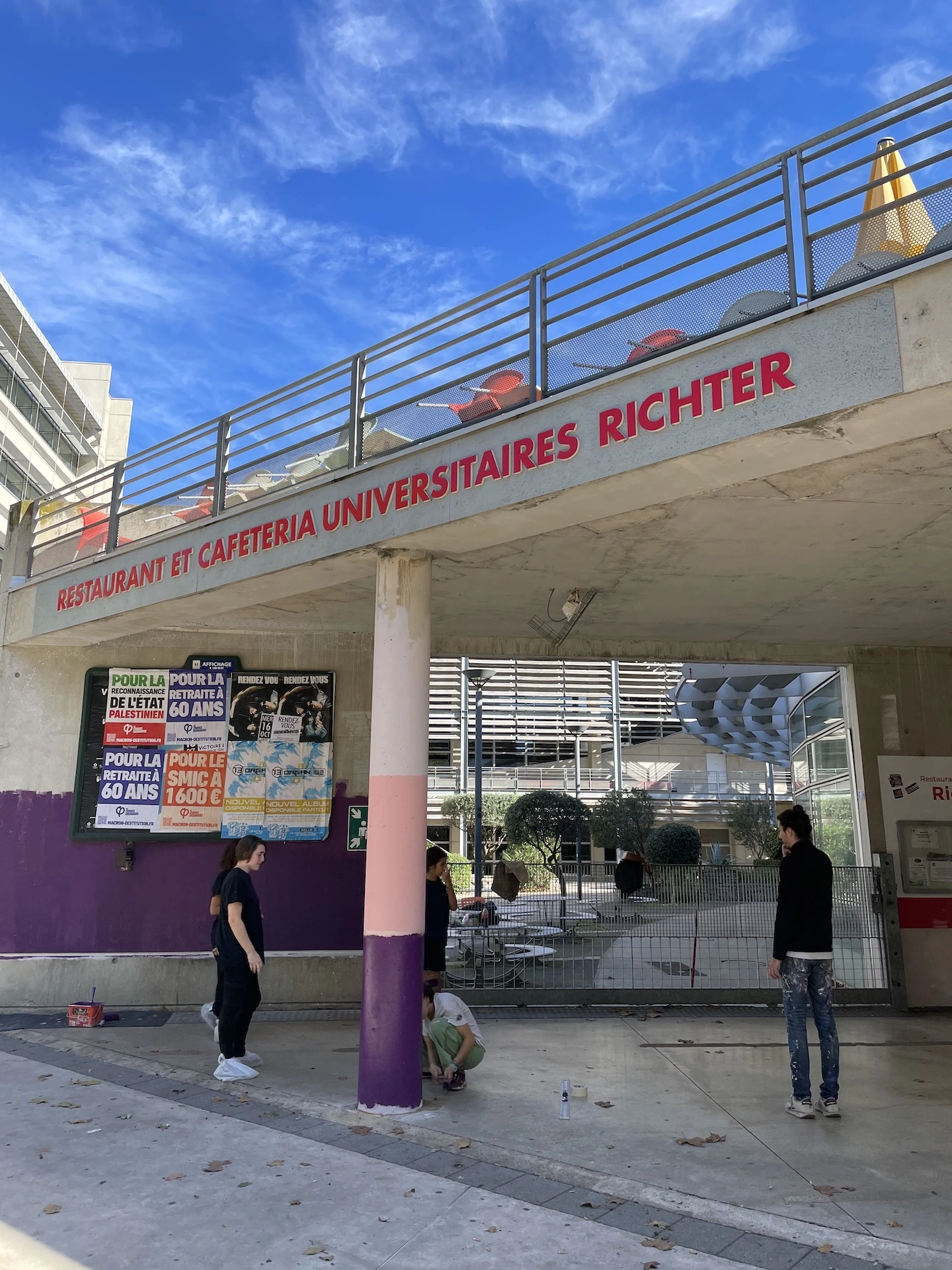 Entrée du restaurant universitaire Richter à Montpellier, avec une fresque murale visible sur le pilier