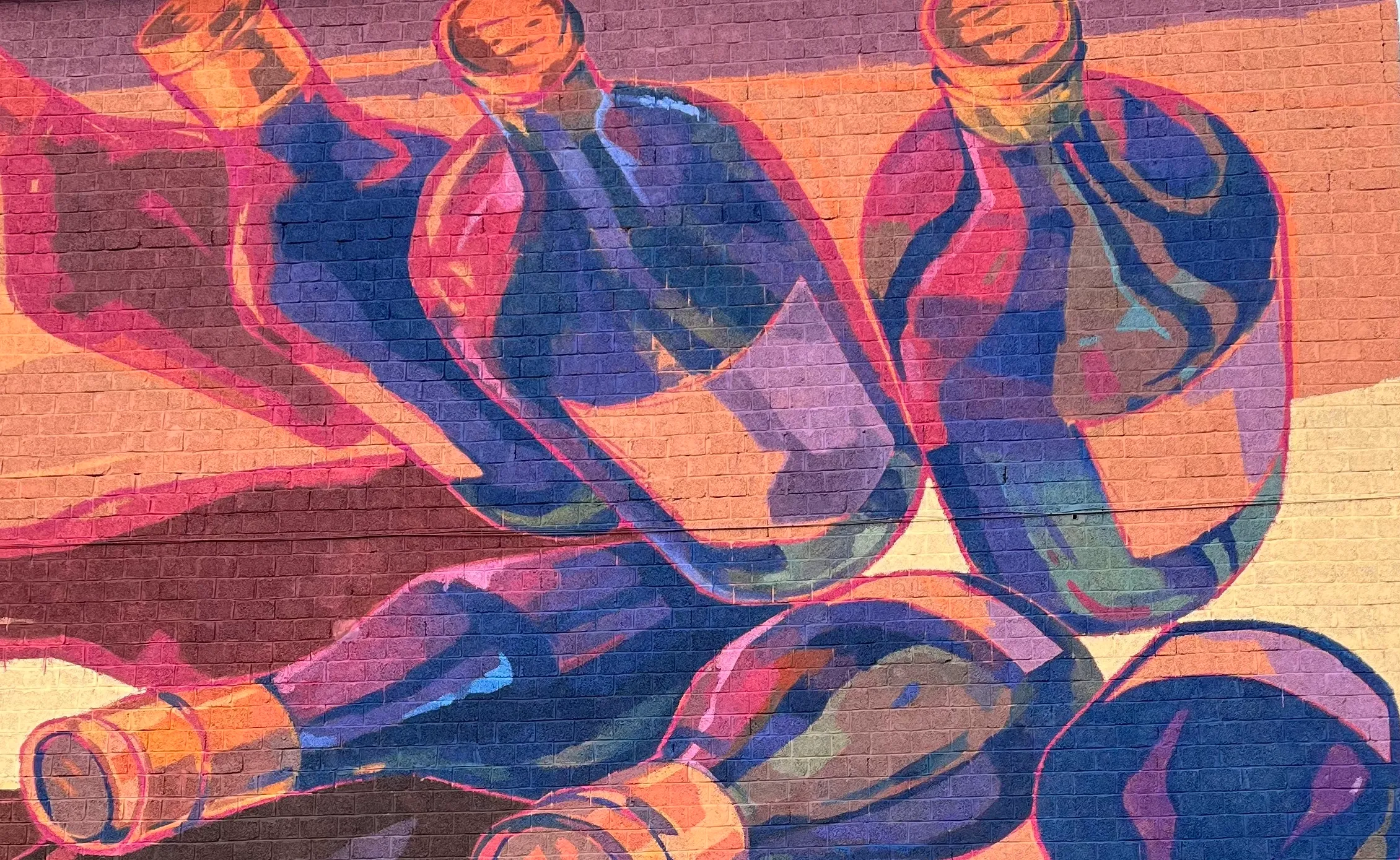 Gros plan de bouteilles de vins peintes dans des couleurs chaudes.