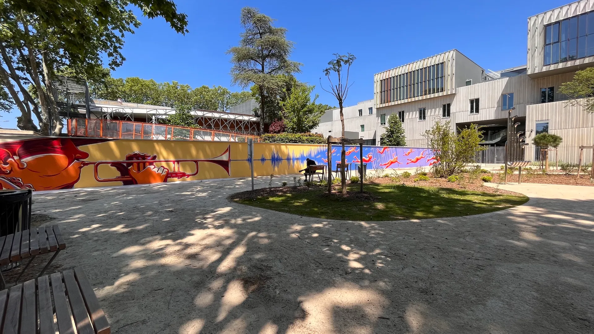 Photo d'un parc avec une vue sur la fresque au fond.