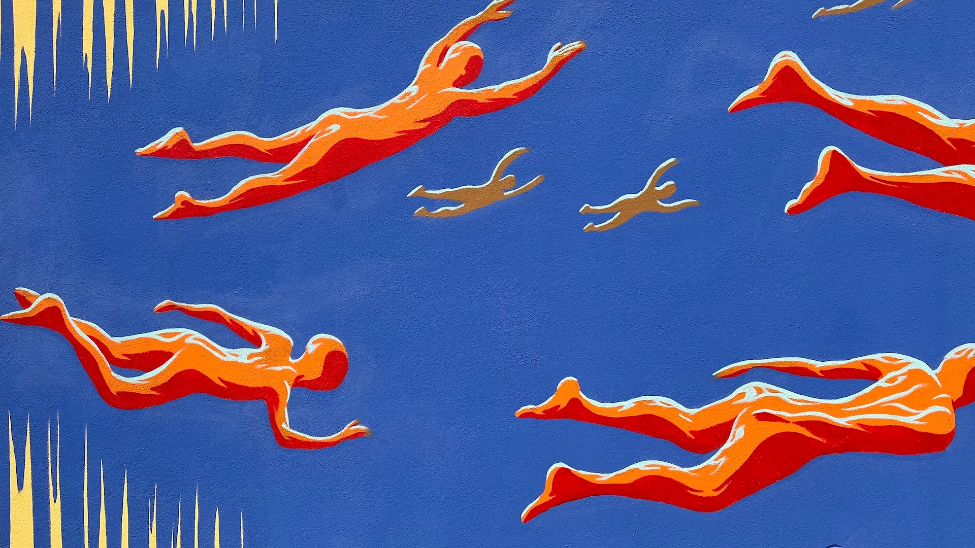 Détail d’une fresque montrant des figures humaines rouges stylisées nageant sur fond bleu.