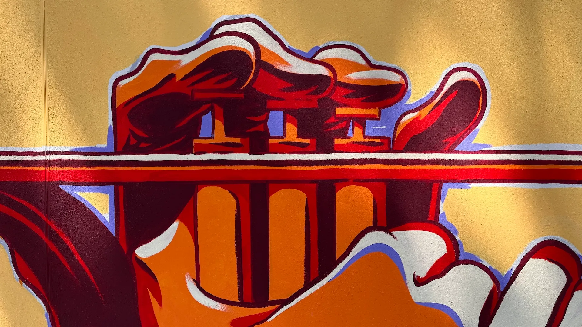 Gros plan sur un élément de la fresque représentant des formes abstraites rouges et violettes.